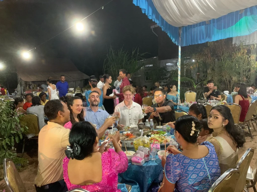 The volunteers and other guests sharing a circular table for drinking and eating